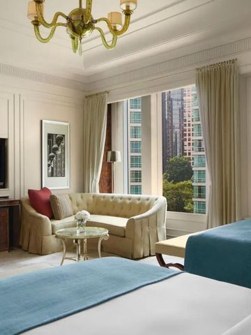 Helles Zimmer mit bequemer Sitzgelegenheit und Stadtblick aus dem Fenster