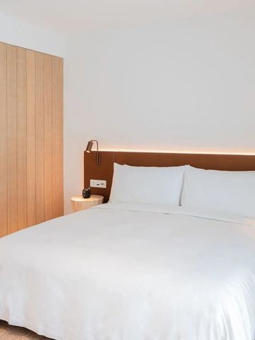 Gemütliches Hotelzimmer mit einem großen Bett und hölzernen Akzenten