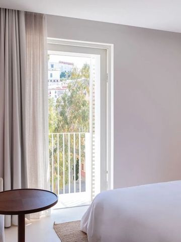 Helles Hotelzimmer mit großen Fenstern und Blick ins Grüne