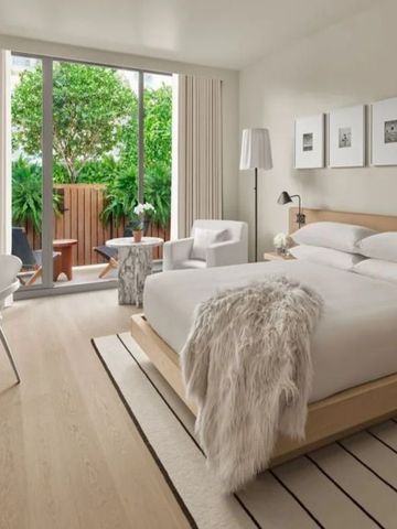 Modernes Hotelzimmer mit großem Bett und Zugang zur Terrasse im Freien