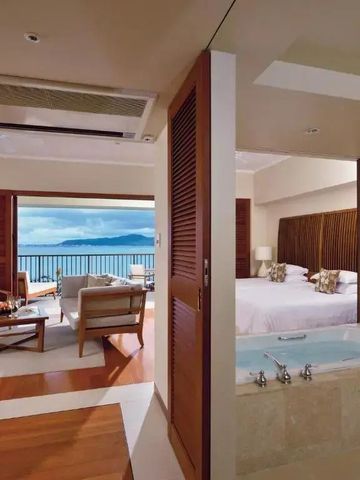 Luxuriöses Zimmer mit Meerblick, separater Badewanne und gemütlicher Sitzecke.