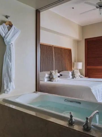Elegantes Hotelzimmer mit freistehender Badewanne und Kingsize-Bett.