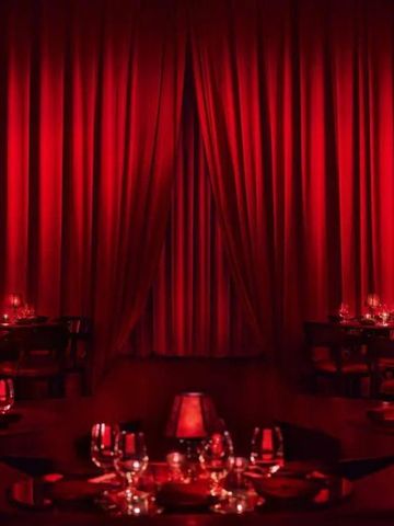 Lounge mit roter Beleuchtung und eleganter Tischdekoration.