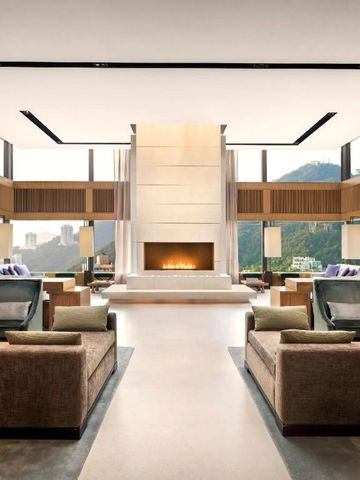 Großzügiger Raum mit Kamin und Panoramafenstern zu den Bergen.