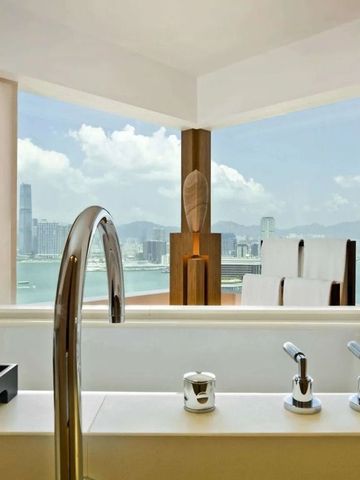 Modernes Badezimmer mit freistehender Badewanne und Blick auf die Stadt und das Wasser.
