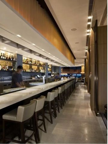 Moderne Hotelbar mit langer Theke und Barhockern