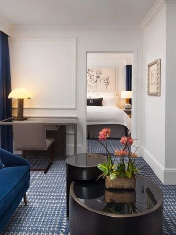 Elegantes Hotelzimmer mit Schreibtisch, Sofa und Blumenarrangement in modernem Design