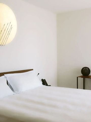 Helles Zimmer mit minimalistischem Dekor und Kunst an der Wand.