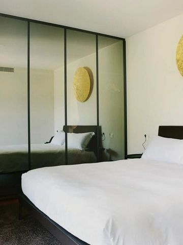 Schlafzimmer mit großem Spiegel und schlichter Dekoration