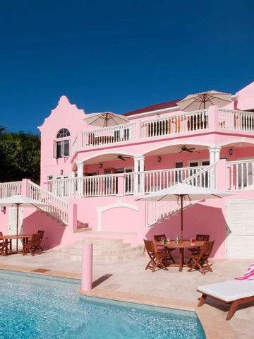 Villa am Pool mit hellblauem Himmel im Hintergrund.