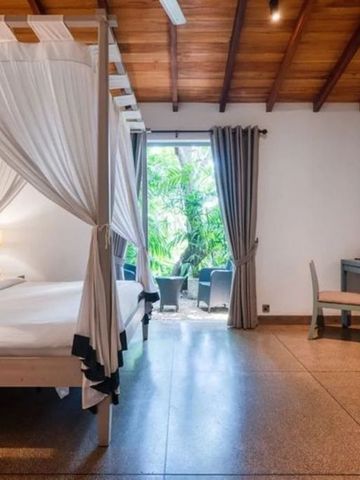 Luftiges Schlafzimmer mit Himmelbett und Blick auf Terrasse