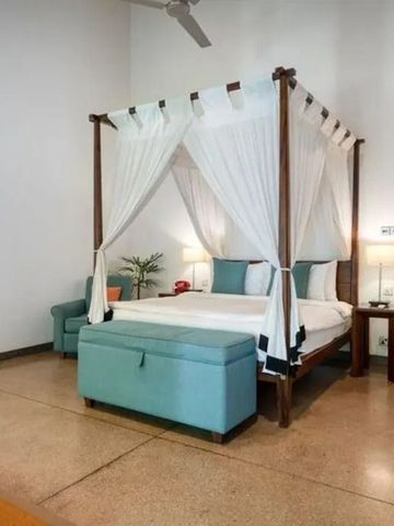 Helles Zimmer mit Himmelbett und Sitzgelegenheit