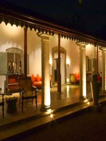 Beleuchtete Veranda eines kolonialen Gebäudes bei Nacht