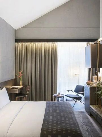 Helles Hotelzimmer mit großem Bett und stilvollem Dekor