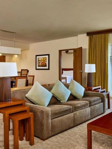 Geräumiges Wohnzimmer einer Suite mit komfortabler Einrichtung und Balkonzugang