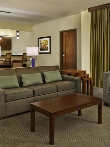 Wohnbereich einer Suite mit modernen Möbeln und Zugang zur Küche