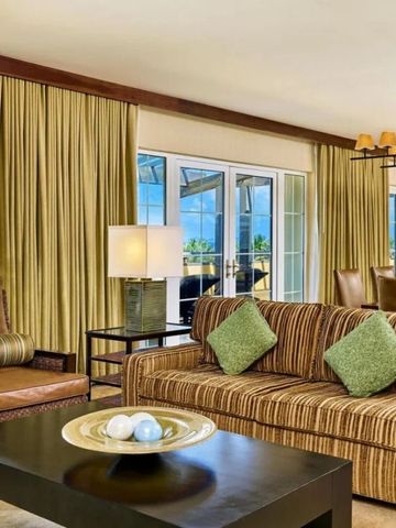 Geräumiges Wohnzimmer einer Suite mit modernen Möbeln und hellen Farben