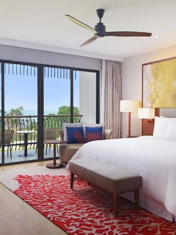 Helles Schlafzimmer mit Kingsize-Bett und Balkon mit Meerblick