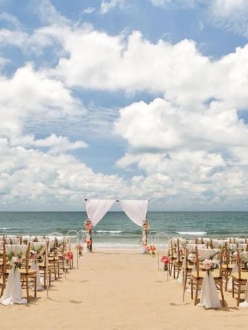 Strandhochzeit mit Stühlen und Blumendekoration vor dem Meer
