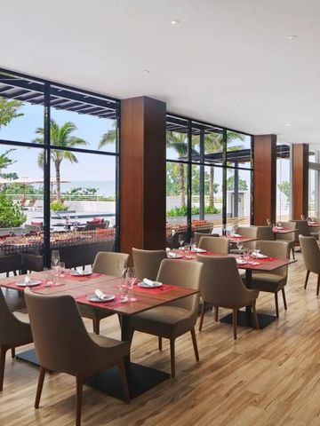 Geräumiges Restaurant mit Blick auf den Außenbereich und stilvollen Sitzgelegenheiten.