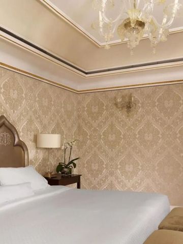 Edles Schlafzimmer mit luxuriöser Tapete und großer Deckenleuchte