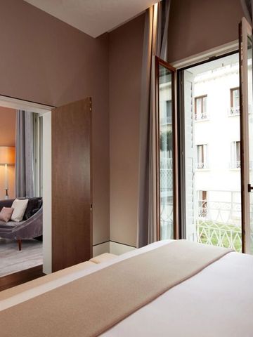 Helles Schlafzimmer mit Zugang zu einem gemütlichen Wohnbereich und großem Fenster