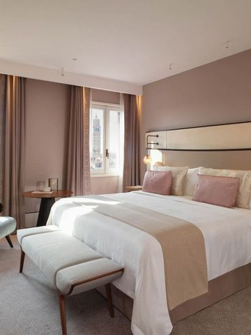 Geräumiges Schlafzimmer mit Doppelbett und Sitzbereich mit Blick auf Venedig