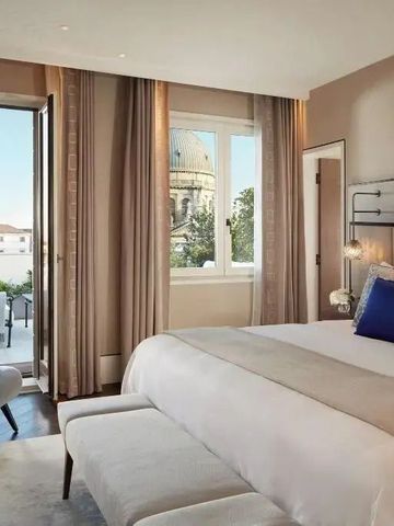 Zimmer mit großem Fenster und Zugang zu einer Terrasse mit Blick auf eine Kuppel