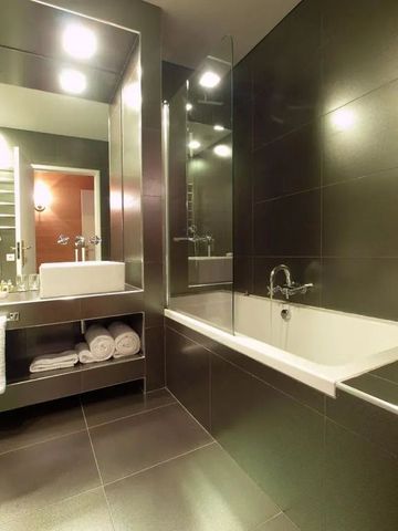 Elegantes Badezimmer mit Badewanne und großem Spiegel