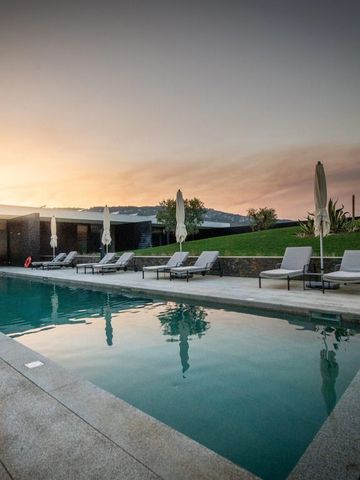 Außenpool mit Liegestühlen bei Sonnenuntergang