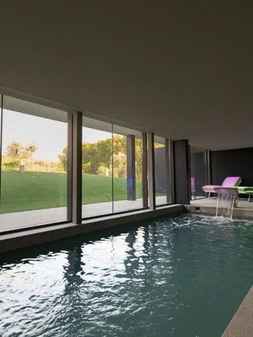 Innenpool mit Liegen und großem Fenster