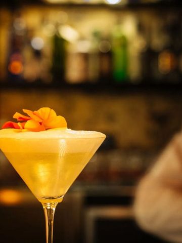 Eleganter Cocktail mit Blütendekoration in Hotelbar