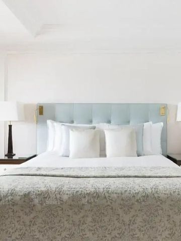 Hauptschlafzimmer mit gepolstertem Kopfteil und eleganter Bettwäsche.