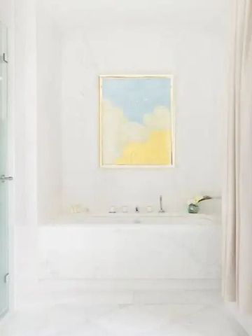 Helles Badezimmer mit Kunstwerk und Wanne für entspannende Momente