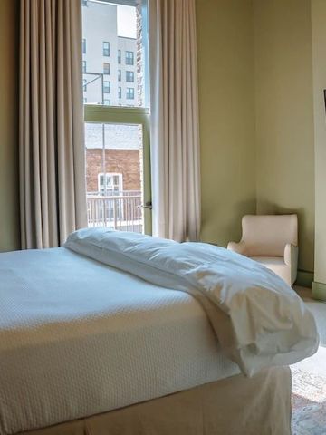 Geräumiges Schlafzimmer mit großem Fenster und modernem Bett