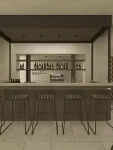 Moderne Hotelbar mit eleganten Hockern und einer Auswahl an Flaschen im Hintergrund