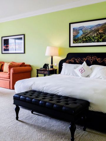 Charmantes Zimmer mit Doppelbett und Sofa in warmen Farben.