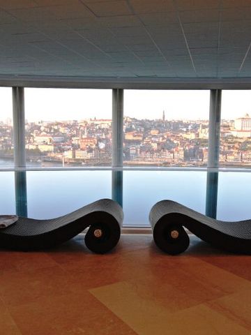 Innenpool mit Panoramafenstern und Blick auf Porto