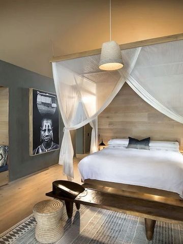 Elegantes Schlafzimmer mit Himmelbett und Holzdetails in gehobener Ausstattung