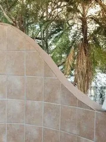 Private Außendusche aus Fliesen mit Blick auf Bäume