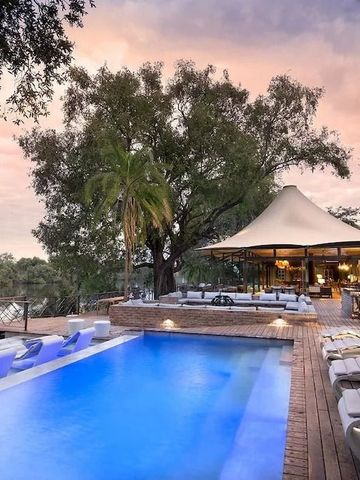 Traumhafte Poollandschaft mit Liegen und überdachtem Loungebereich im Hintergrund