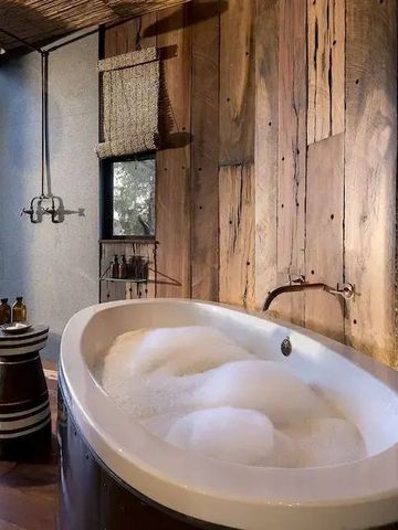 Luxuriöse Badewanne in einem stilvoll gestalteten Holzinterieur mit Außenblick