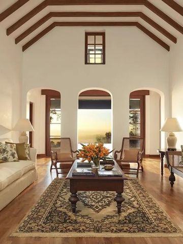 Stilvoller Wohnraum mit hoher Decke und großen Fenstern