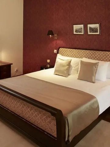 Elegantes Hotelzimmer mit King-Size-Bett und stilvoller Holzmöblierung