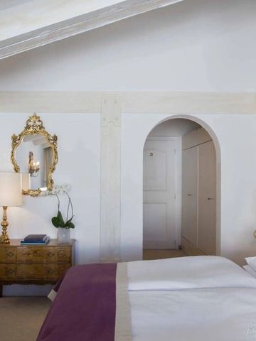 Elegantes Gästezimmer mit antiken Möbeln und lila Bettdecke