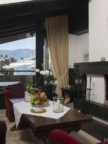 Gemütlicher Lounge-Bereich mit Kamin und Panoramablick auf die Berge