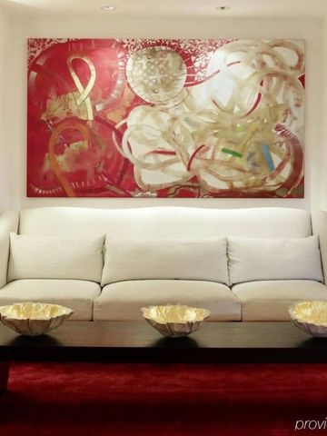 Eleganter Lounge-Bereich mit weißem Sofa und zeitgenössischem Kunstwerk