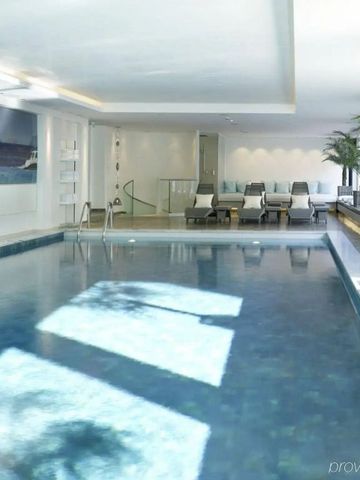 Moderner Innenpoolbereich mit Liegestühlen und Pflanzen