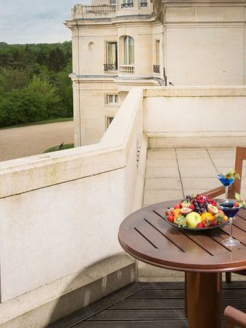 Elegante Terrasse mit Obstteller und Cocktails, Aussicht auf klassisches Gebäude