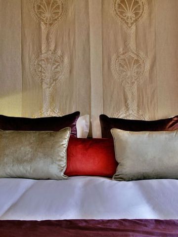 Geräumiges Bett mit dekorativen Kissen und elegantem Kopfteil im Hotel Tiara Yaktsa